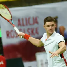 Kamil Majchrzak w akcji na korcie, przygotowuje się do uderzenia. Jego zarobki w tenisie z pewnością rosną wraz z kolejnymi wygranymi.