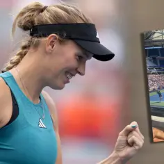 Uśmiechnięta duńska tenisistka polskiego pochodzenia, Caroline Wozniacki, świętuje zwycięstwo na korcie.