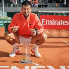 Novak Djoković, z pucharem w rękach, świętuje kolejne zwycięstwo. Jego sukcesy w wielkim szlemie mężczyzn są niezrównane.
