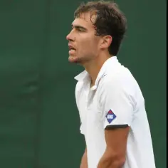 Jerzy Janowicz, tenisista, którego majątek budowany jest na sukcesach sportowych, w białej koszulce z logo Atlas.
