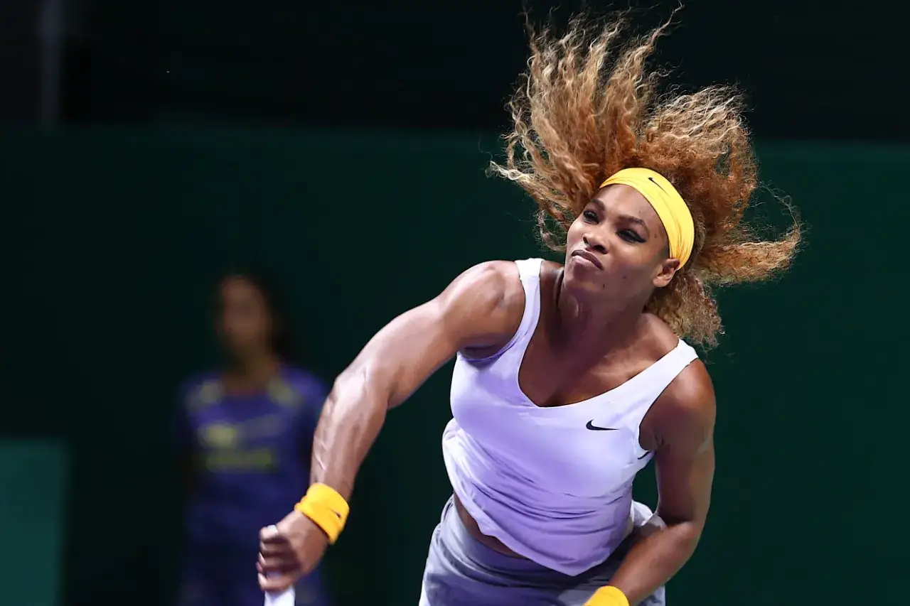 Amerykańska tenisistka Serena Williams w akcji, z włosami rozwianymi podczas serwisu.