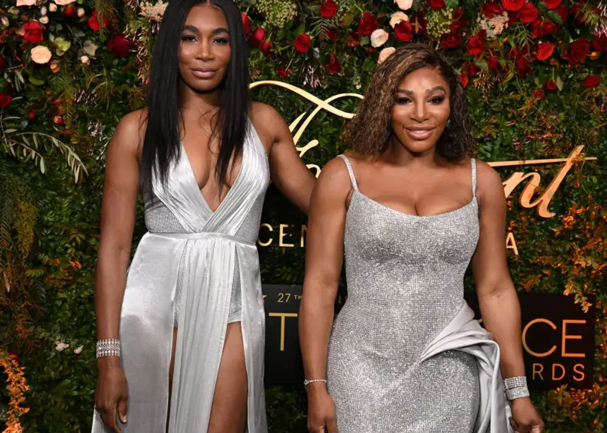 Siostry Venus i Serena Williams, słynne amerykańskie tenisistki, błyszczą na ściance w srebrnych kreacjach.